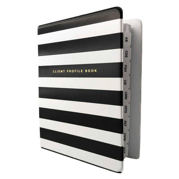 Angled view of black and white striped salon client profile book. Alpha divider tabs peeking out.