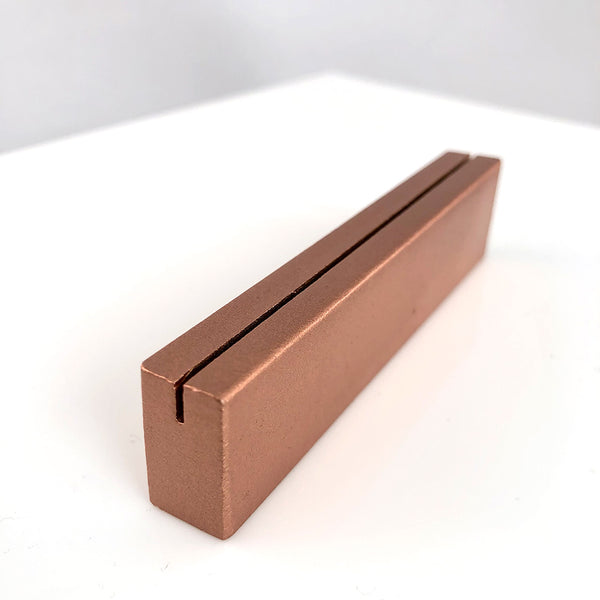 Angled view of copper metal tabletop sign stand